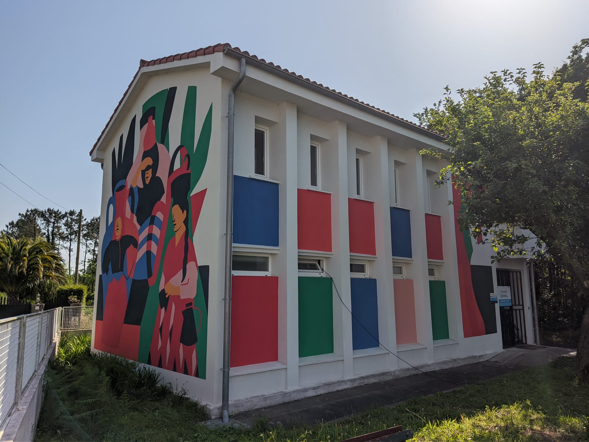 A artista Ceciro pintou na antiga escola de Firmistáns un mural dedicado ás leiteiras e ao traballo das mulleres amesás