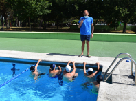 Nenos en piscina con profesor